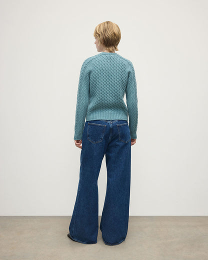 Model wears Johnstons of Elgin AW25 Women's Knitwear Seascape Aran Cable Green Cashmere Jumper Back View KAI05086HC0038