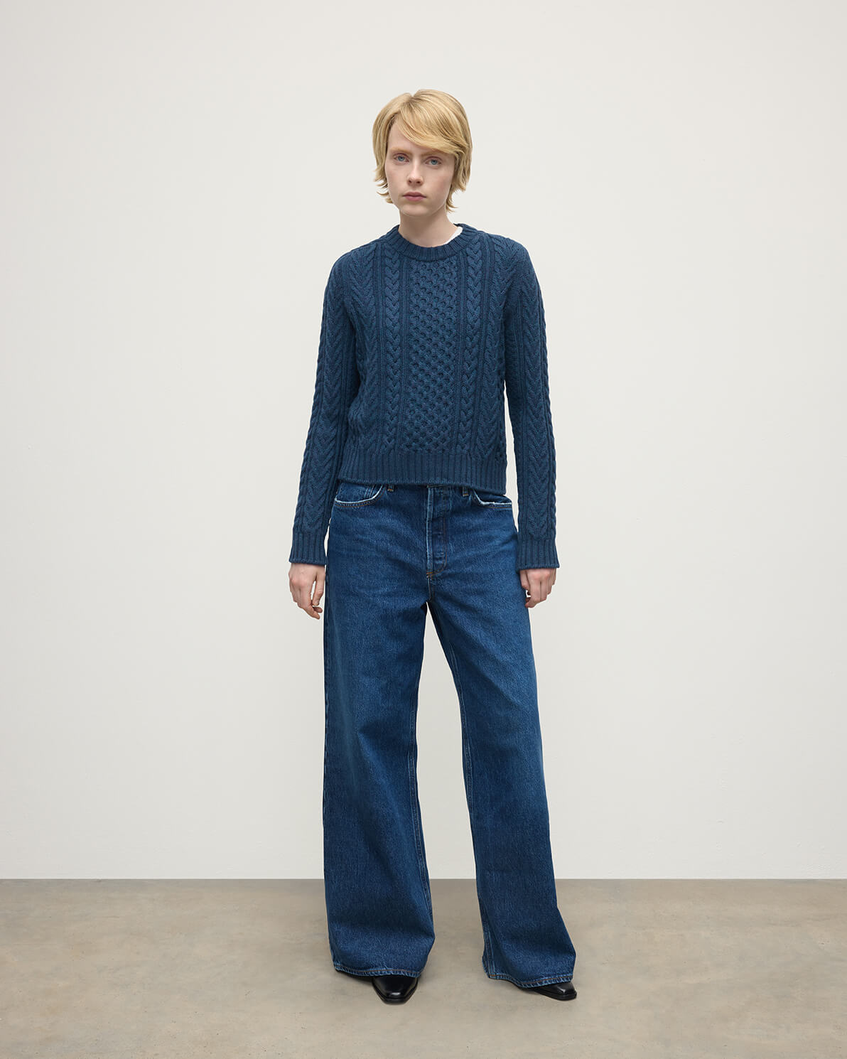 Model wears Johnstons of Elgin AW25 Women's Knitwear Heather Navy Aran Cable Navy Cashmere Jumper Front View KAI05086HD7321