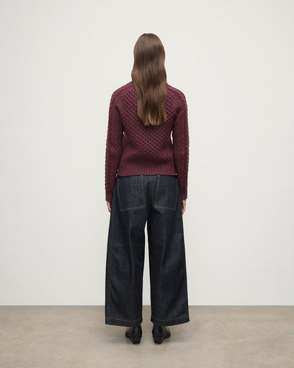 Model wears Johnstons of Elgin AW25 Women's Knitwear Damson Aran Cable Purple Cashmere Jumper  Back View KAI05086HE7064