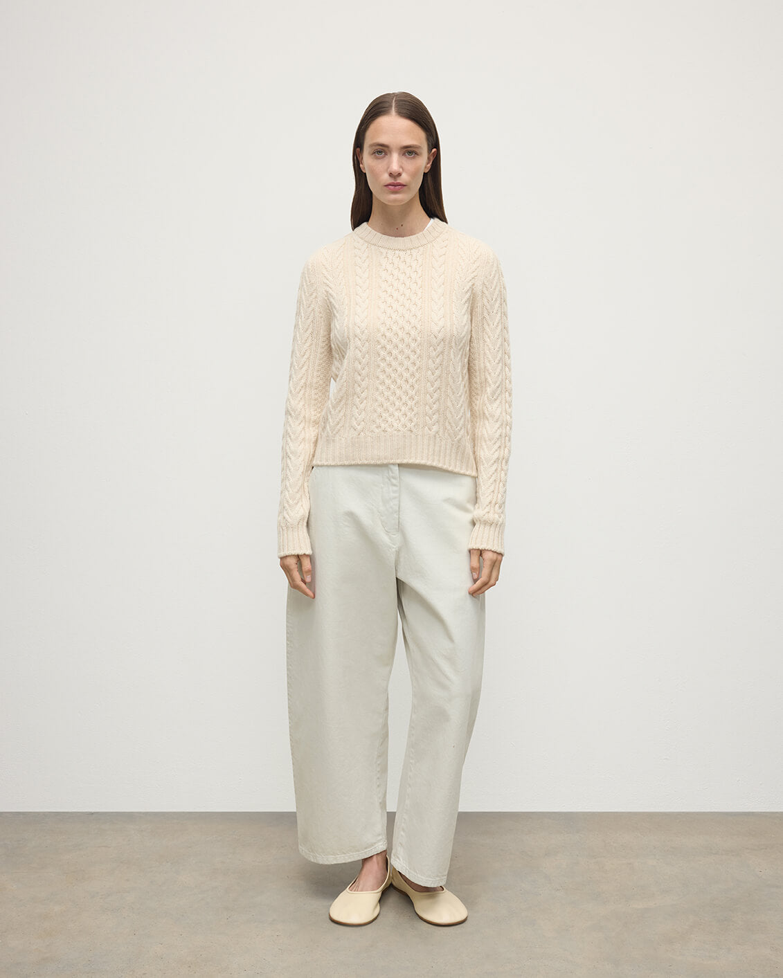 Model wearing Johnstons of Elgin AW25 Women's Knitwear Champagne Aran Cable Cream Cashmere Jumper Front View KAI05086SA0502