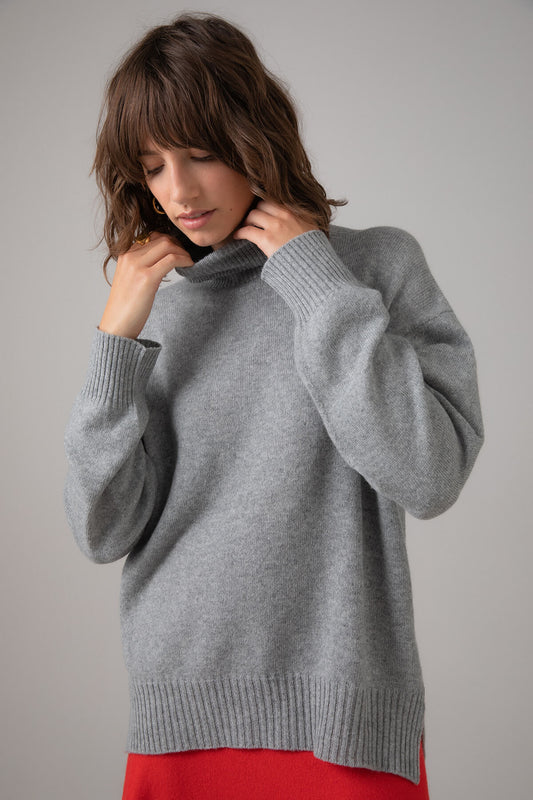 Johnstons of Elgin Women's Gauzy Cashmere Roll Neck with Stepped Hem in Light Grey on a grey background KAI05100HA0308