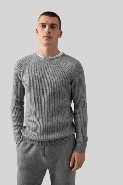 Johnstons of Elgin’s Men's Ribbed Cashmere Round Neck Jumper in Light Grey on model wearing grey joggers on a grey background KAI05105HA0308