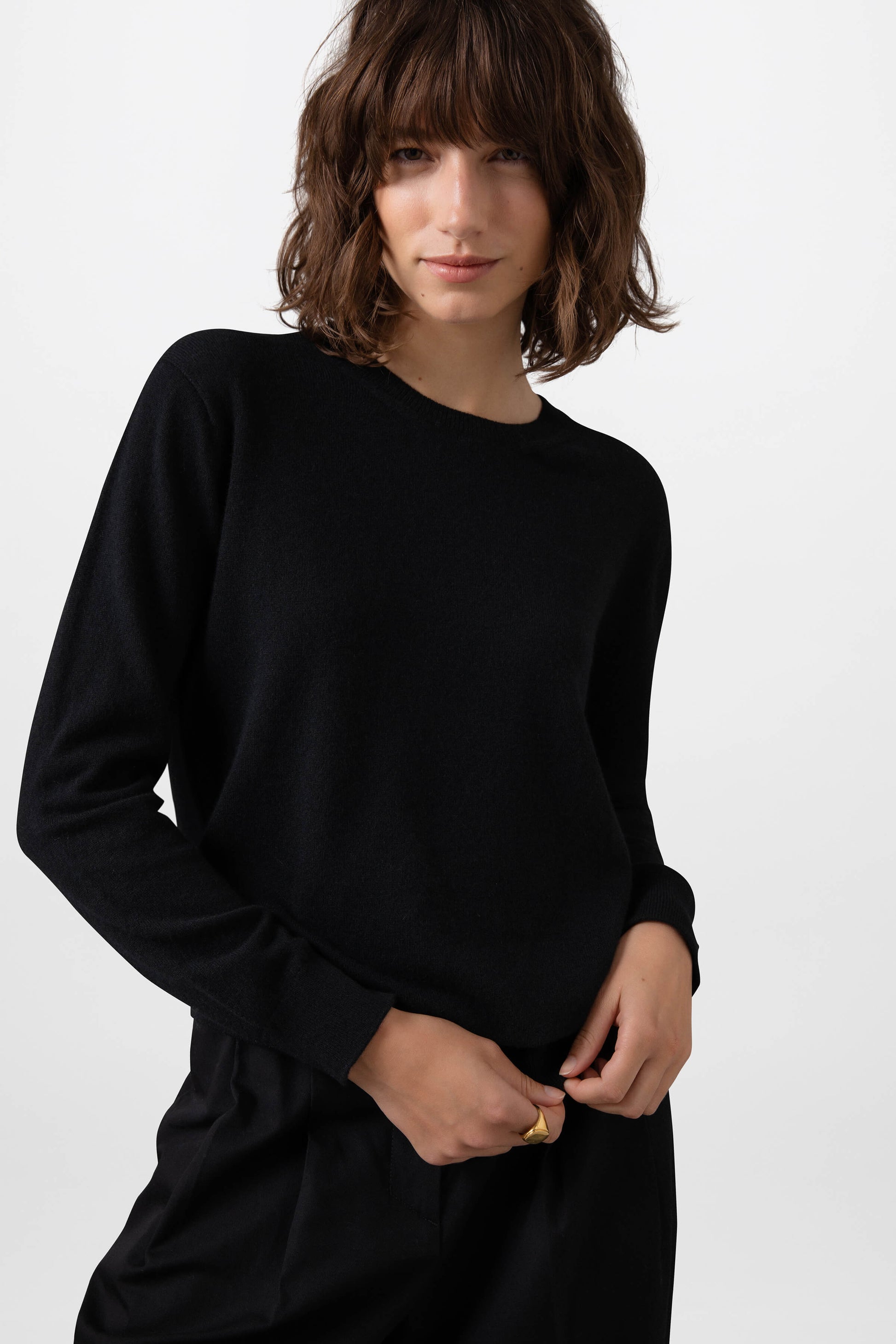 Person wearing a black long-sleeve dress against a white background KAI05139SA0900