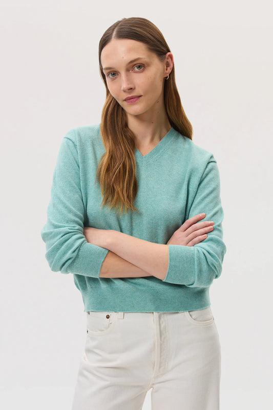 Model wearing Johnstons of Elgin SS25 Women's Knitwear Jade Classic Cashmere V Neck Jumper on a white backdrop KAI05143HC4284