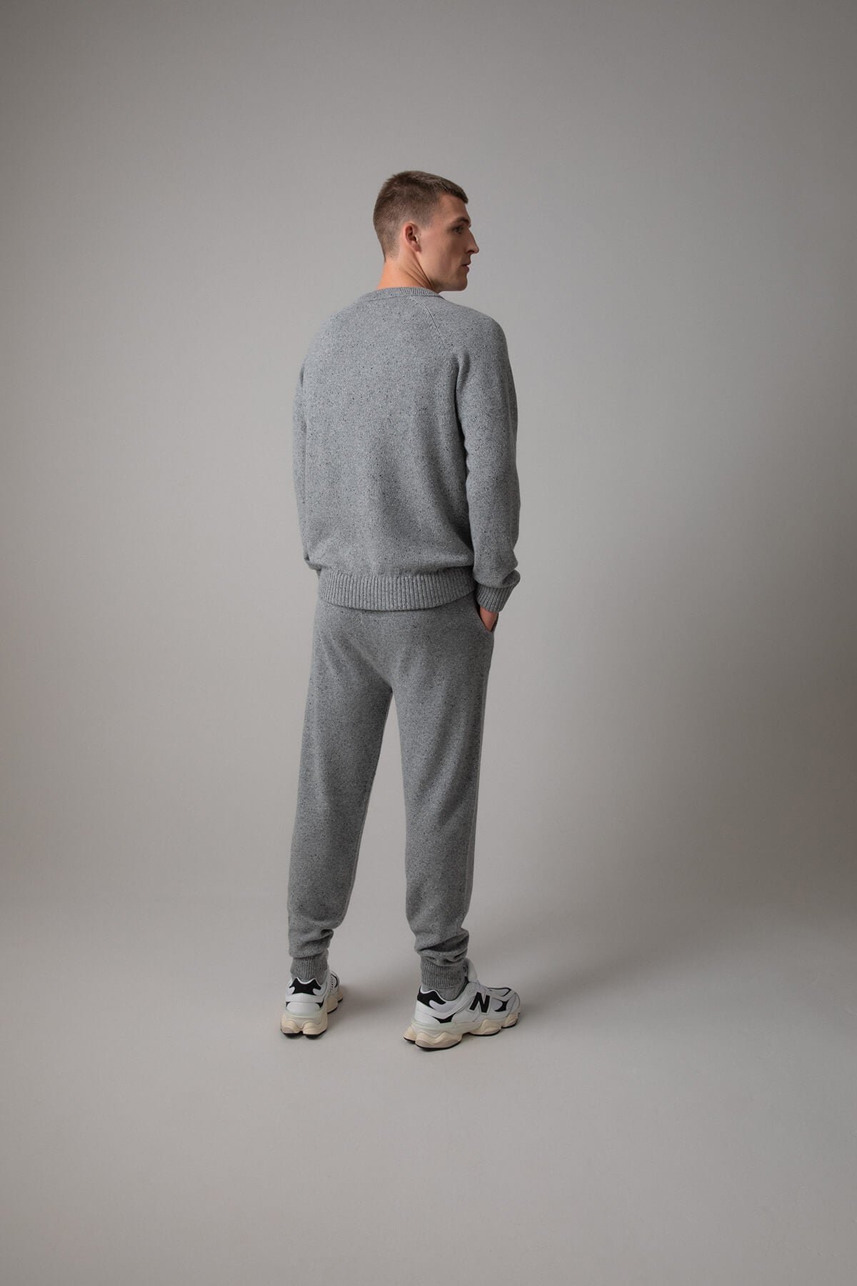 Johnstons of Elgin’s Men's Cashmere Donegal Joggers in Light grey on model wearing matching grey cashmere jumper on a grey background KAI05146004542