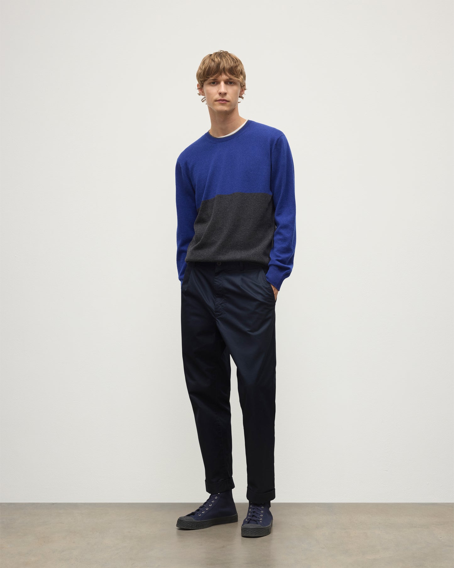 MODEL WEARING JOHNSTONS OF ELGIN MENS SHADED CREW SWEATER GREY 100% CASHMERE OVER A WHITE  T-SHIRT WITH NAVY TROUSERS KAI05232Q25945