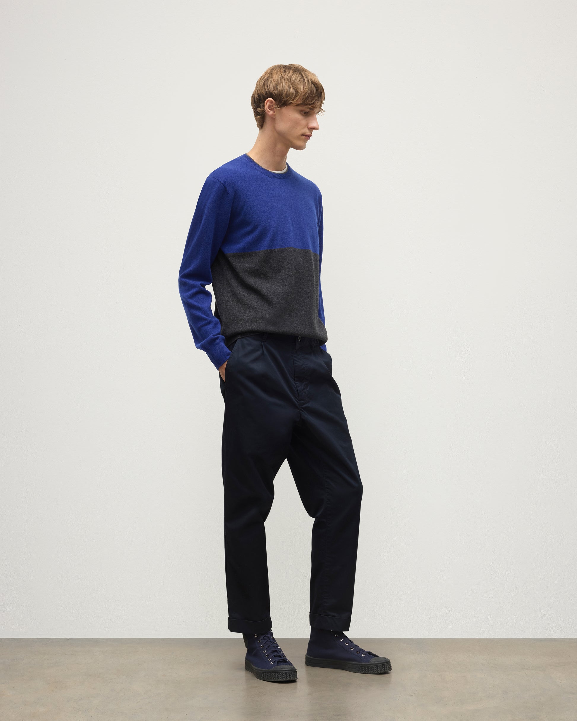 MODEL WEARING JOHNSTONS OF ELGIN MENS SHADED CREW SWEATER GREY 100% CASHMERE OVER A WHITE  T-SHIRT WITH NAVY TROUSERS KAI05232Q25945