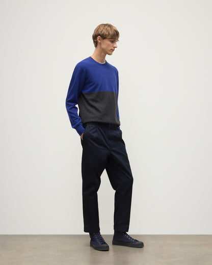 MODEL WEARING JOHNSTONS OF ELGIN MENS SHADED CREW SWEATER GREY 100% CASHMERE OVER A WHITE  T-SHIRT WITH NAVY TROUSERS KAI05232Q25945