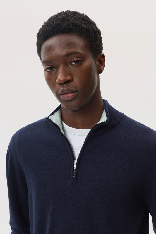 Model wearing Johnstons of Elgin SS25 Men's Knitwear Navy & Mint Contrast Trim Cashmere Zip Neck Sweater KAI05233Q25114