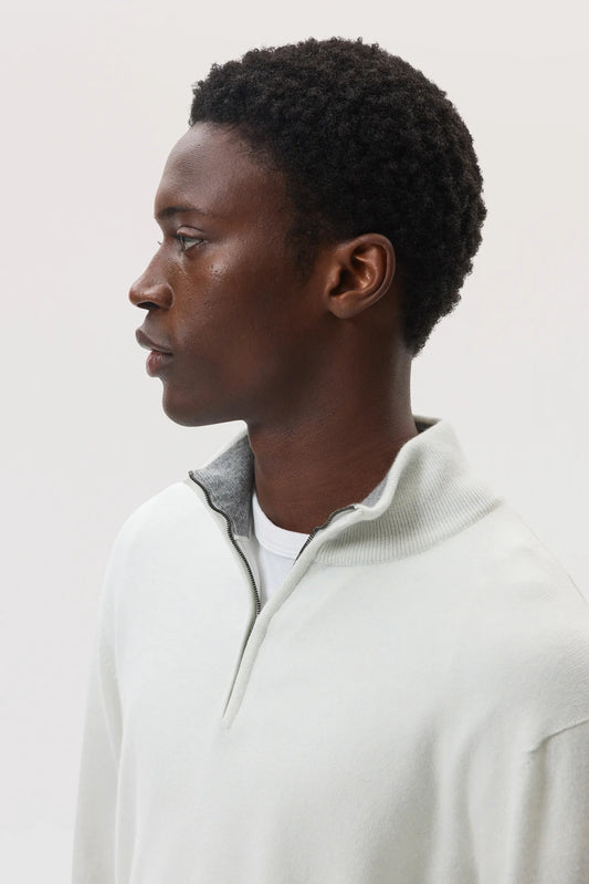 Model wearing Johnstons of Elgin SS25 Men's Knitwear White & Light Grey Contrast Trim Cashmere Zip Neck Jumper on a white backdrop KAI05233Q25115