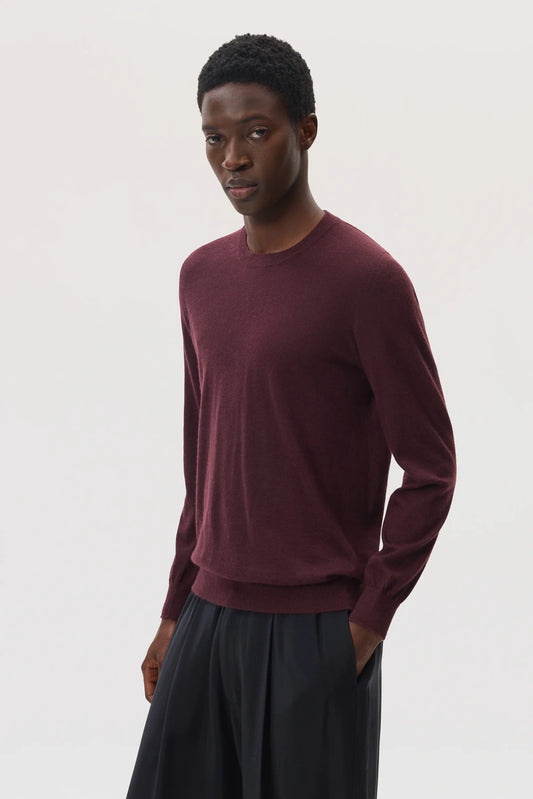 Male model wearing Johnstons of Elgin SS25 Unisex Knitwear Rosewood Superfine Cashmere V Neck Jumper against a white backdrop  KAI05242SB7255