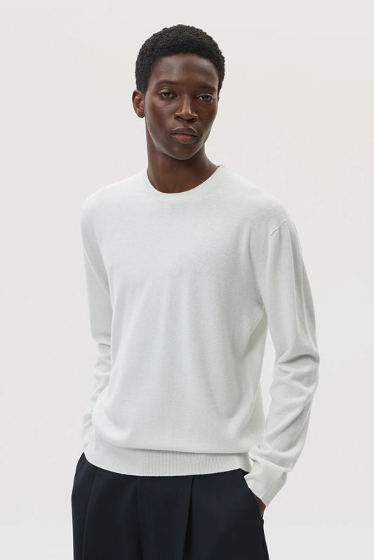 Model wearing Johnstons of Elgin SS25 Men's Knitwear White Classic Cashmere Round Neck Sweater on a white background KAI05265HA0346