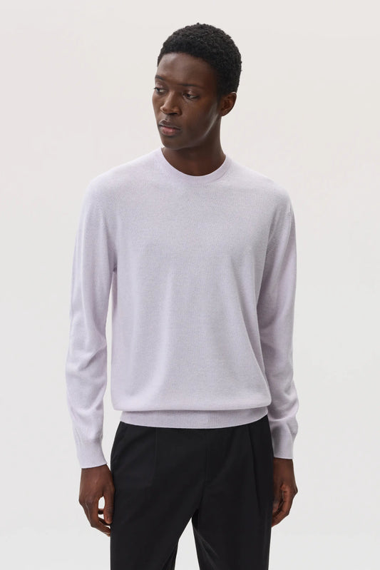 Model wearing Johnstons of Elgin SS25 Men's Knitwear Lavender Classic Cashmere Round Neck Jumper with back trousers KAI05265HD0086