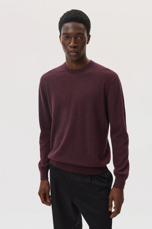 Model wearing Johnstons of Elgin SS25 Men's Knitwear Rosewood Classic Cashmere Round Neck Sweater with lack trousers KAI05265SB7089