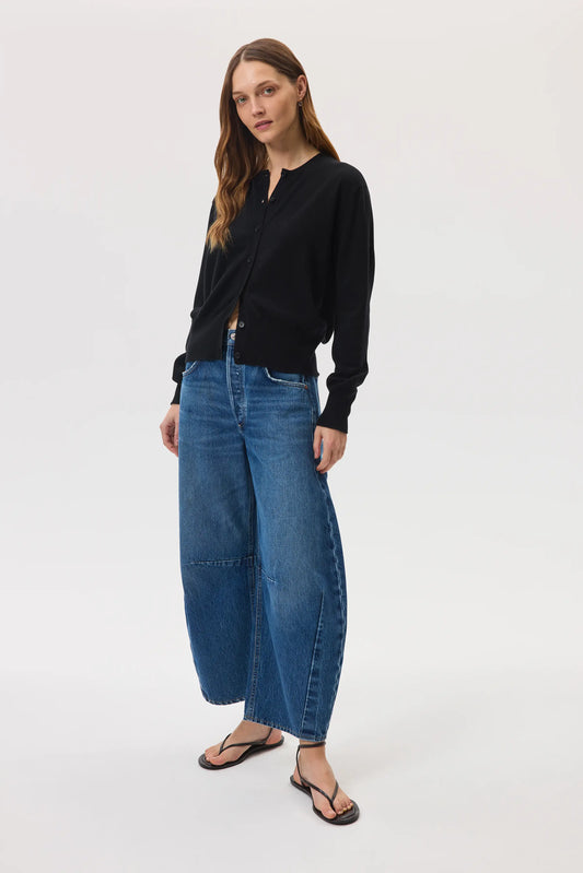 Models wears Johnstons of Elgin SS25 Women's Knitwear Black Classic Cashmere Cardigan with blue barrel leg jeans on a white background  KAI05274SA0900