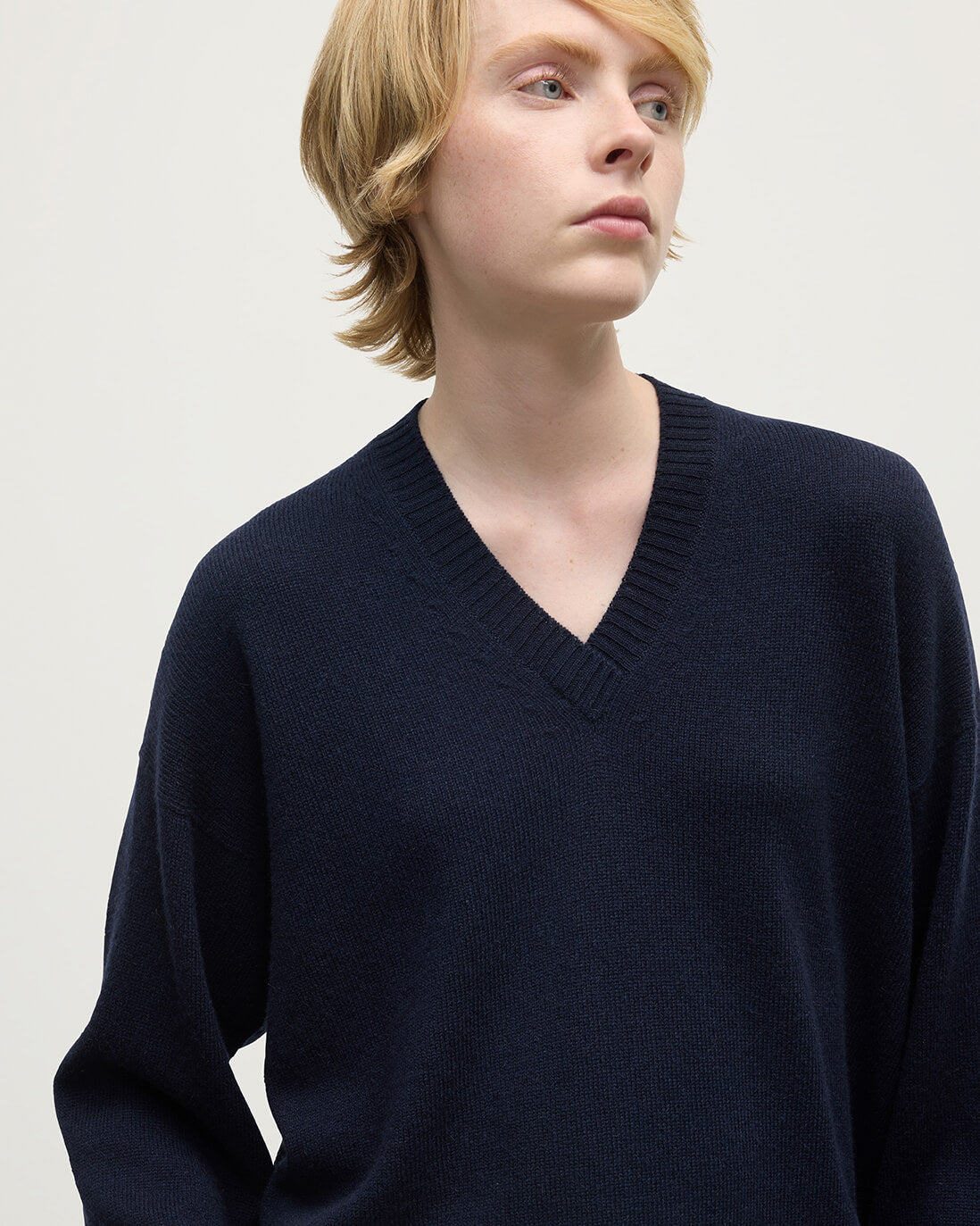 Model wearing Johnstons of Elgin AW25 Women's Knitwear Dark Navy Gauzy Cashmere Navy V Neck Jumper Close Up KAI05323SD7666