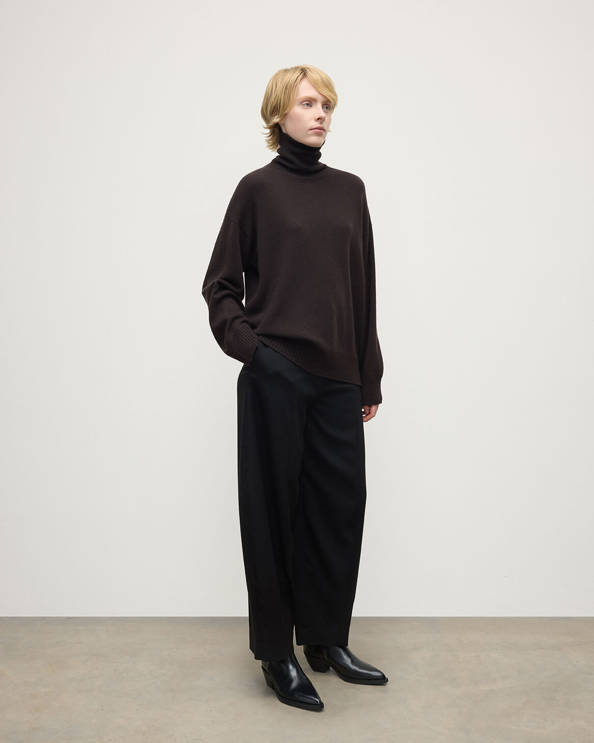 Model wearing Johnstons of Elgin AW25 Women's Knitwear Molasses Gauzy Cashmere Brown Roll Neck Jumper Side View KAI05324SB7290