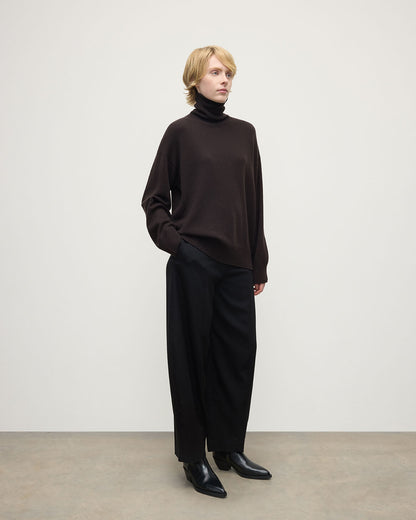 Model wearing Johnstons of Elgin AW25 Women's Knitwear Molasses Gauzy Cashmere Brown Roll Neck Jumper Side View KAI05324SB7290