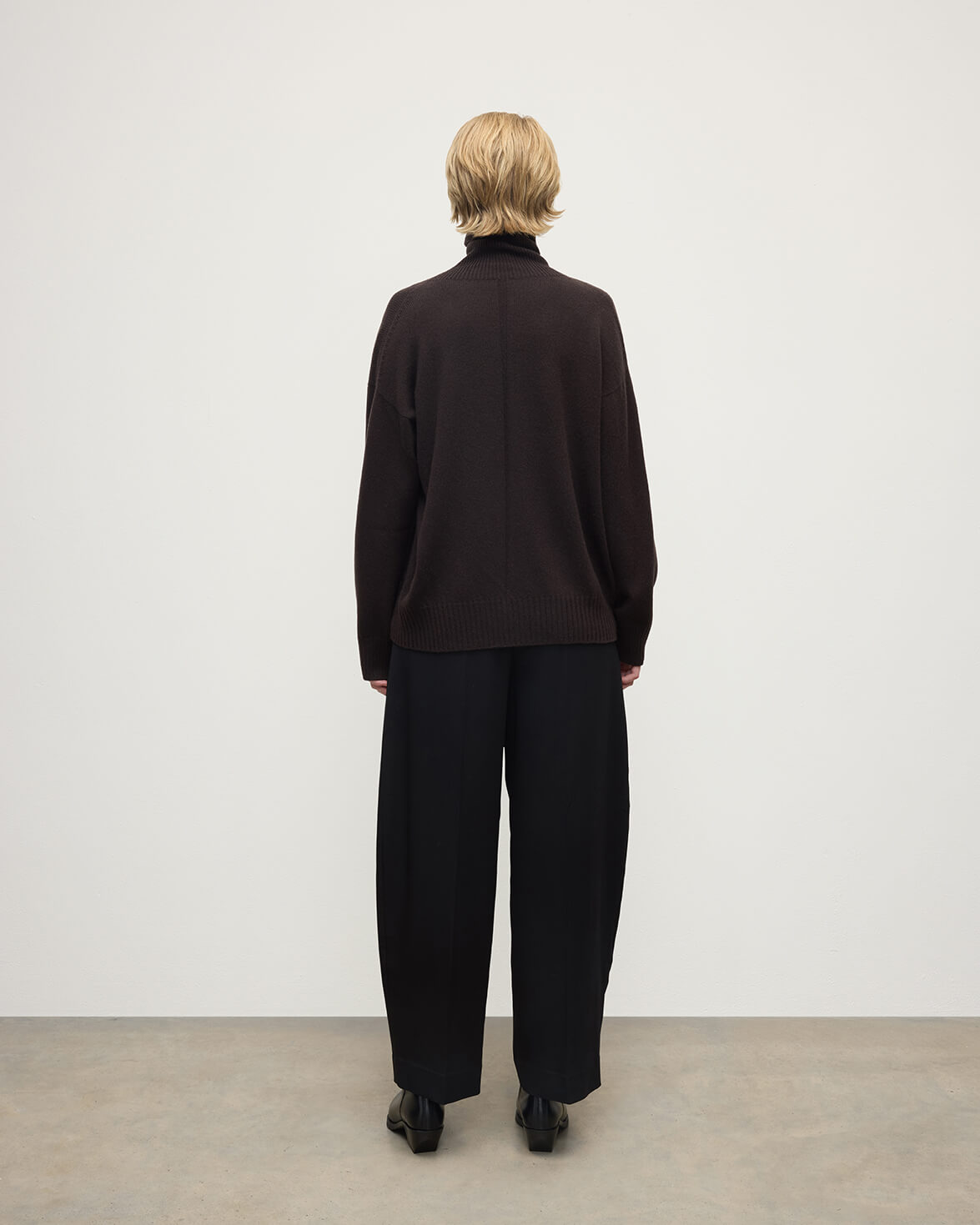 Model wearing Johnstons of Elgin AW25 Women's Knitwear Molasses Gauzy Cashmere Brown Roll Neck Jumper Back View KAI05324SB7290