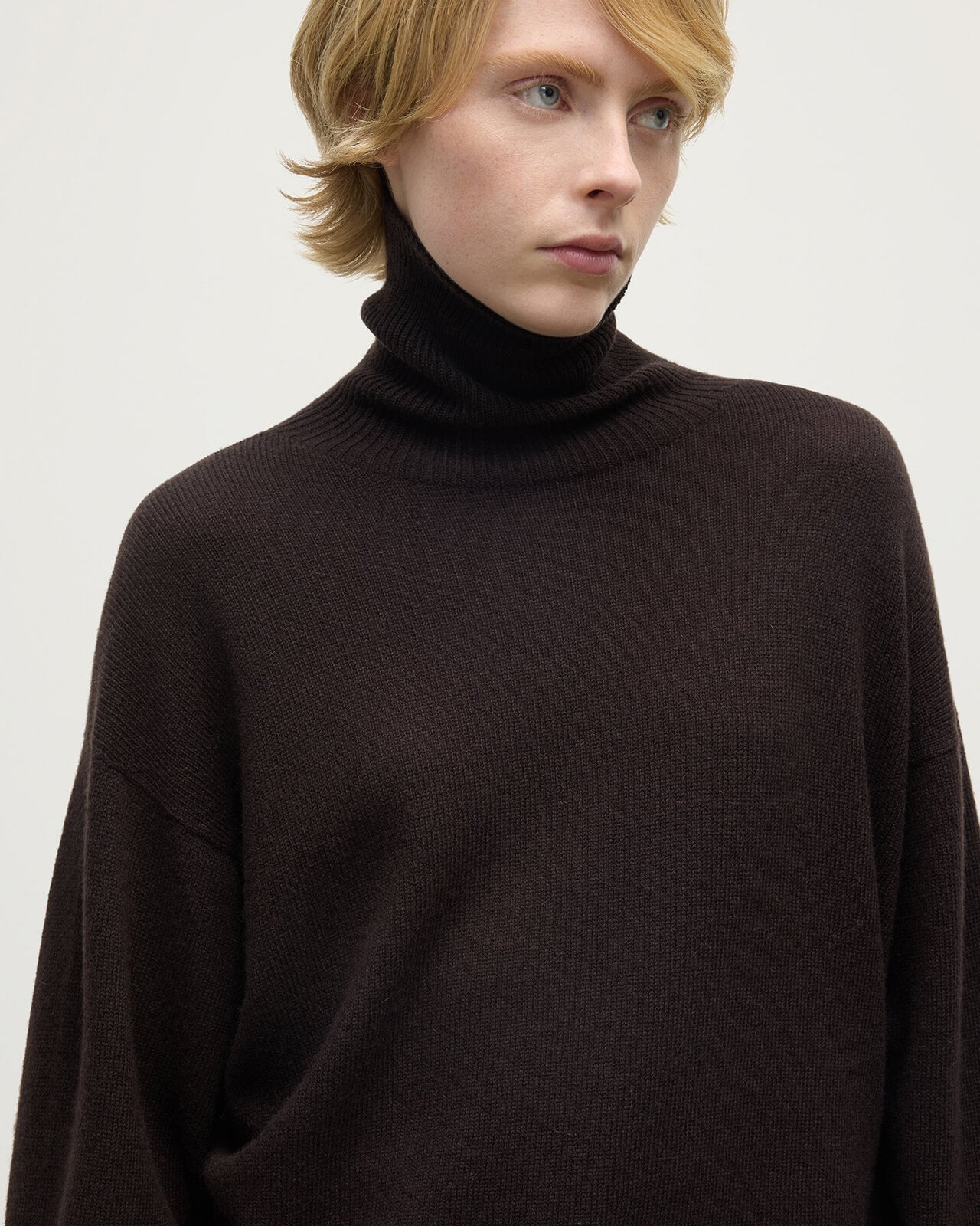 Model wearing Johnstons of Elgin AW25 Women's Knitwear Molasses Gauzy Cashmere Brown Roll Neck Jumper Close Up KAI05324SB7290