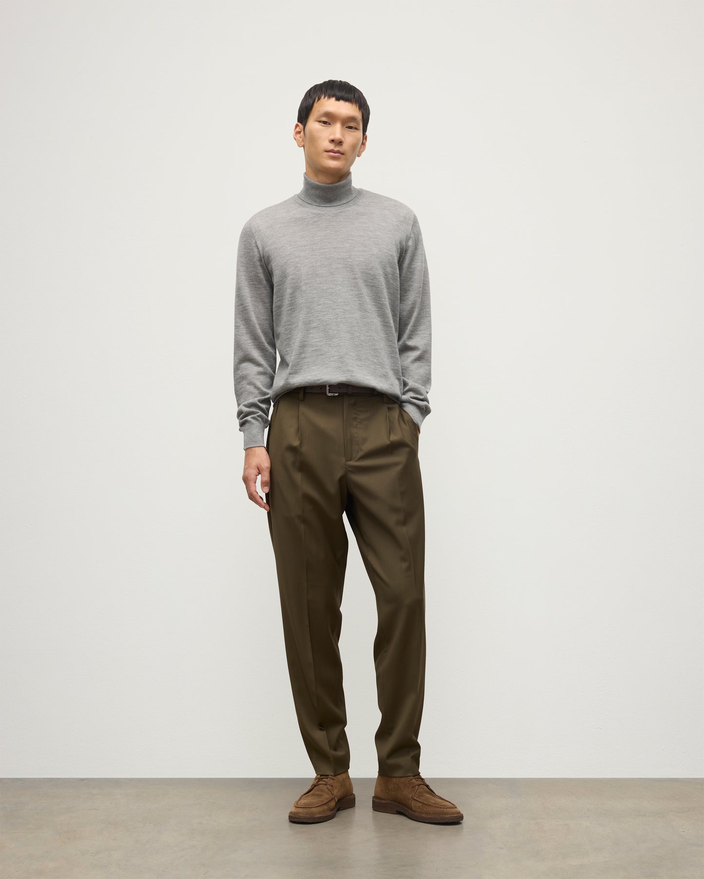 MODEL WEARS JOHNSTONS OF ELGIN MENS SUPERFINE FIN ROLL COLLAR GREY 100% SUPERFINE CASHMERE WITH OLIVE GREEN TROUSERS KAI05333HA4253