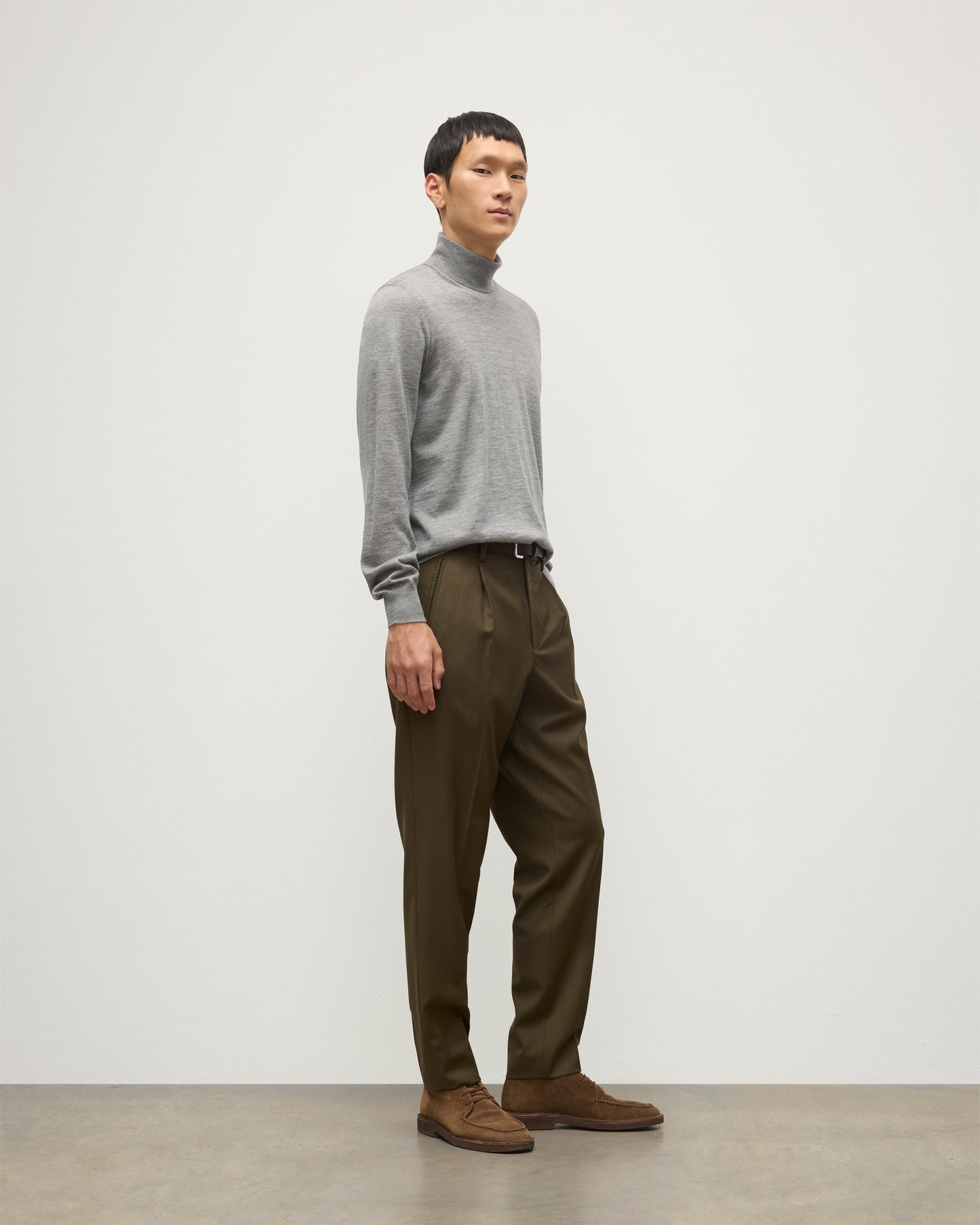 MODEL WEARS JOHNSTONS OF ELGIN MENS SUPERFINE FIN ROLL COLLAR GREY 100% SUPERFINE CASHMERE WITH OLIVE GREEN TROUSERS KAI05333HA4253