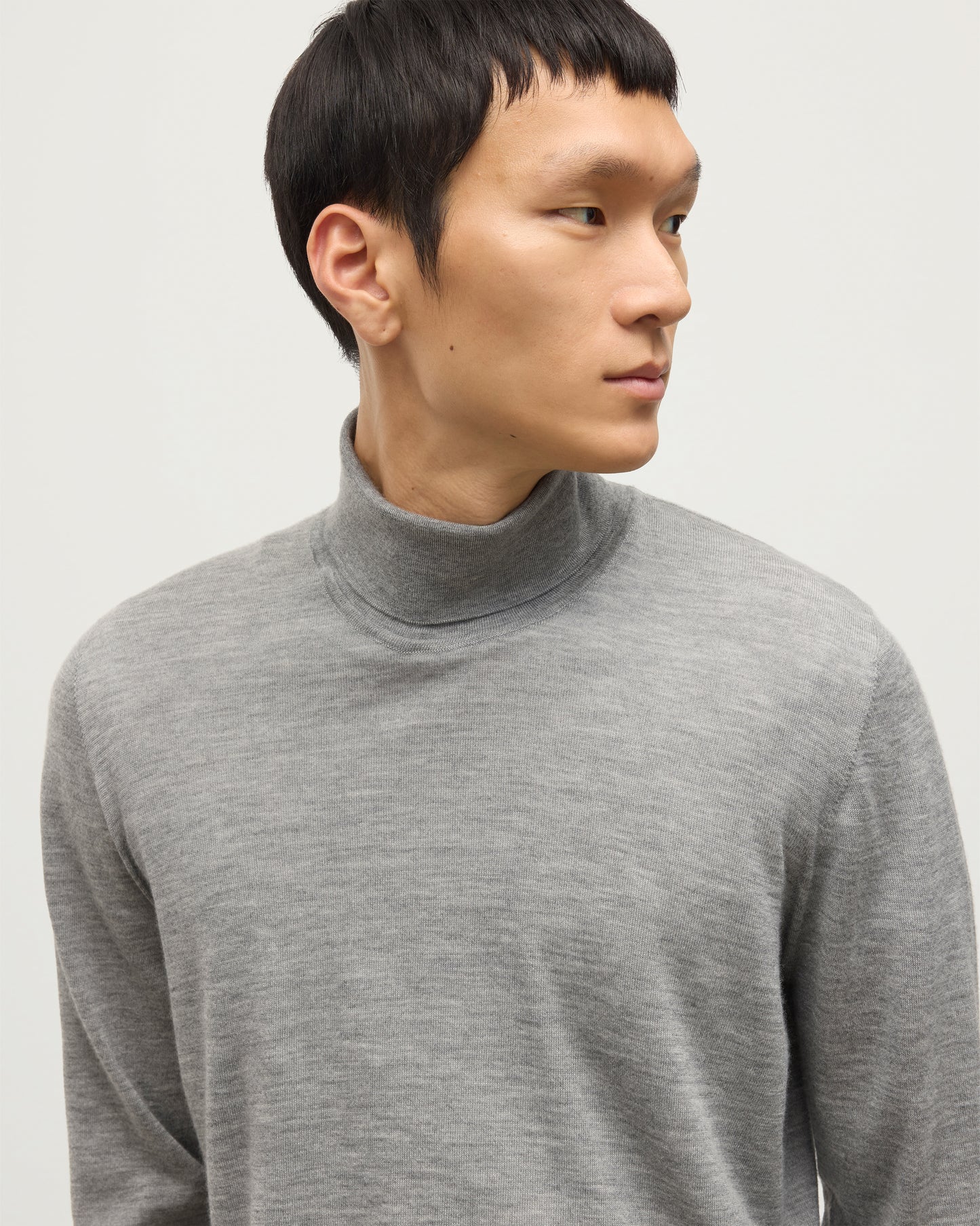 MODEL WEARS JOHNSTONS OF ELGIN MENS SUPERFINE FIN ROLL COLLAR GREY 100% SUPERFINE CASHMERE WITH OLIVE GREEN TROUSERS KAI05333HA4253