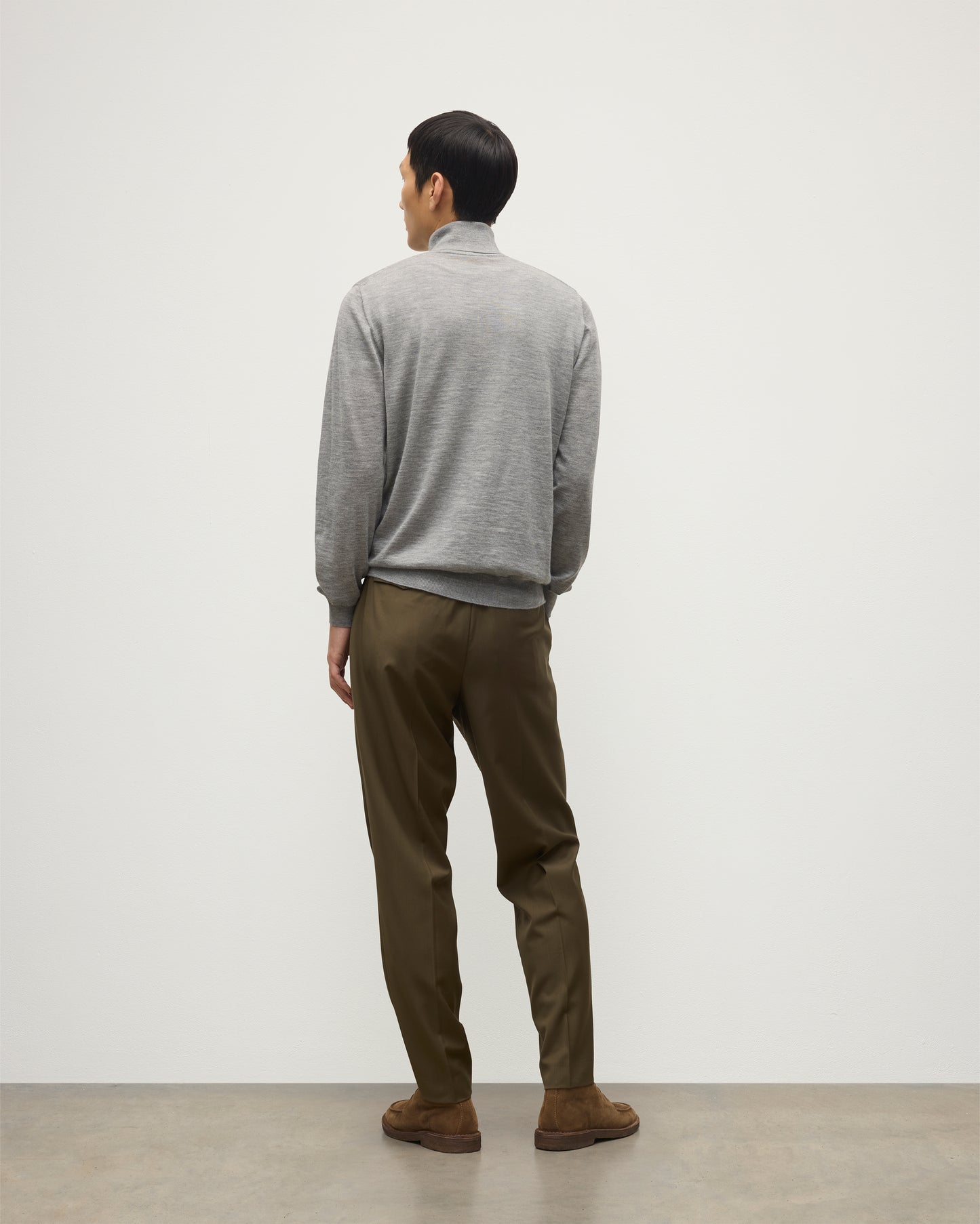 MODEL WEARS JOHNSTONS OF ELGIN MENS SUPERFINE FIN ROLL COLLAR GREY 100% SUPERFINE CASHMERE WITH OLIVE GREEN TROUSERS KAI05333HA4253