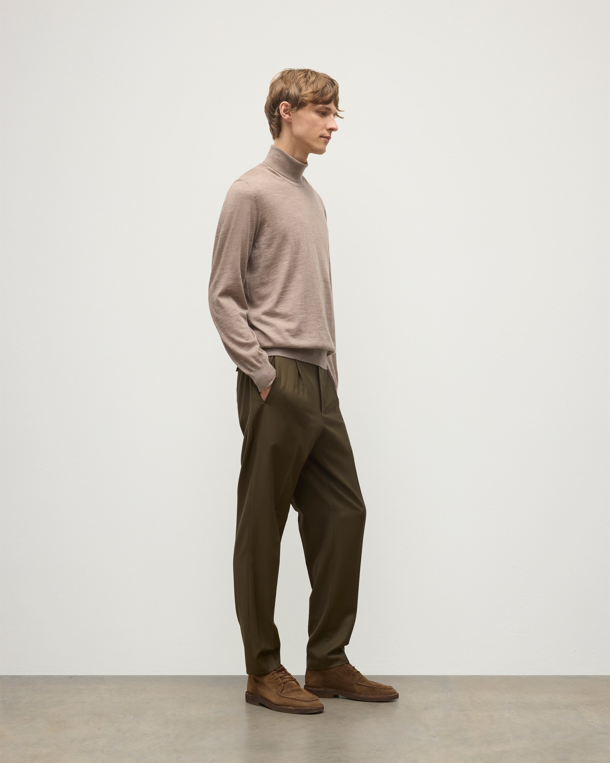 MODEL WEARING JOHNSTONS OF ELGIN MENS SUPERFINE FIN ROLL COLLAR GREY 100% SUPERFINE CASHMERE WITH OLIVE TROUSERS KAI05333HB0273