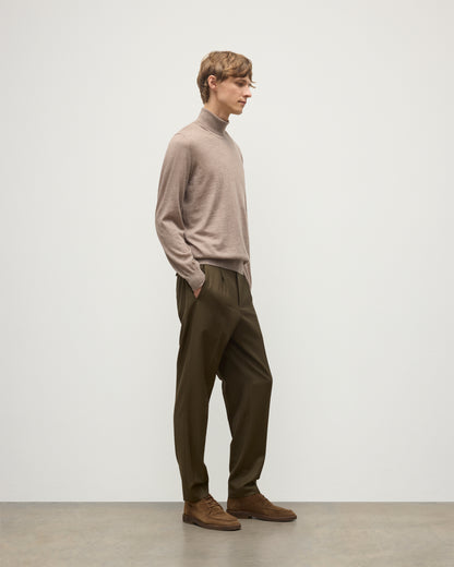 MODEL WEARING JOHNSTONS OF ELGIN MENS SUPERFINE FIN ROLL COLLAR GREY 100% SUPERFINE CASHMERE WITH OLIVE TROUSERS KAI05333HB0273