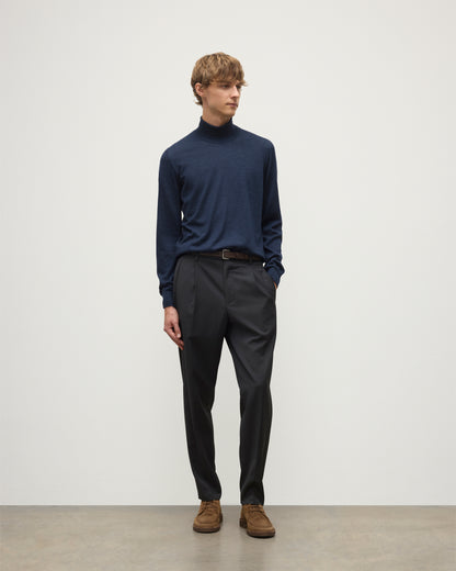 MODEL WEARS JOHNSTONS OF ELGIN MENS SUPERFINE FIN ROLL COLLAR NAVY 100% SUPERFINE CASHMERE  WITH GREY TROUSERS AND BROWN BELT KAI05333HD7350