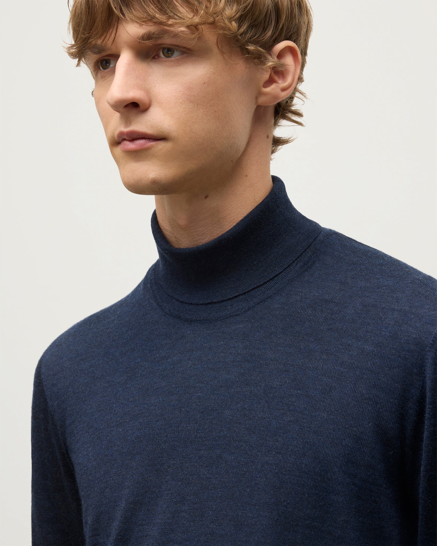MODEL WEARS JOHNSTONS OF ELGIN MENS SUPERFINE FIN ROLL COLLAR NAVY 100% SUPERFINE CASHMERE   KAI05333HD7350