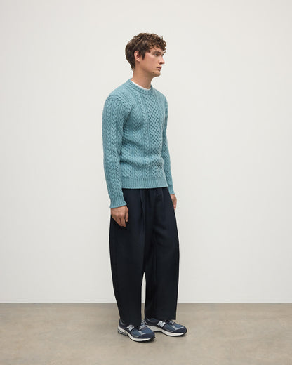 Model wearing Johnstons of Elgin AW25 Men's Knitwear Seascape Aran Cable Green Cashmere Jumper Side KAI05336HC0038