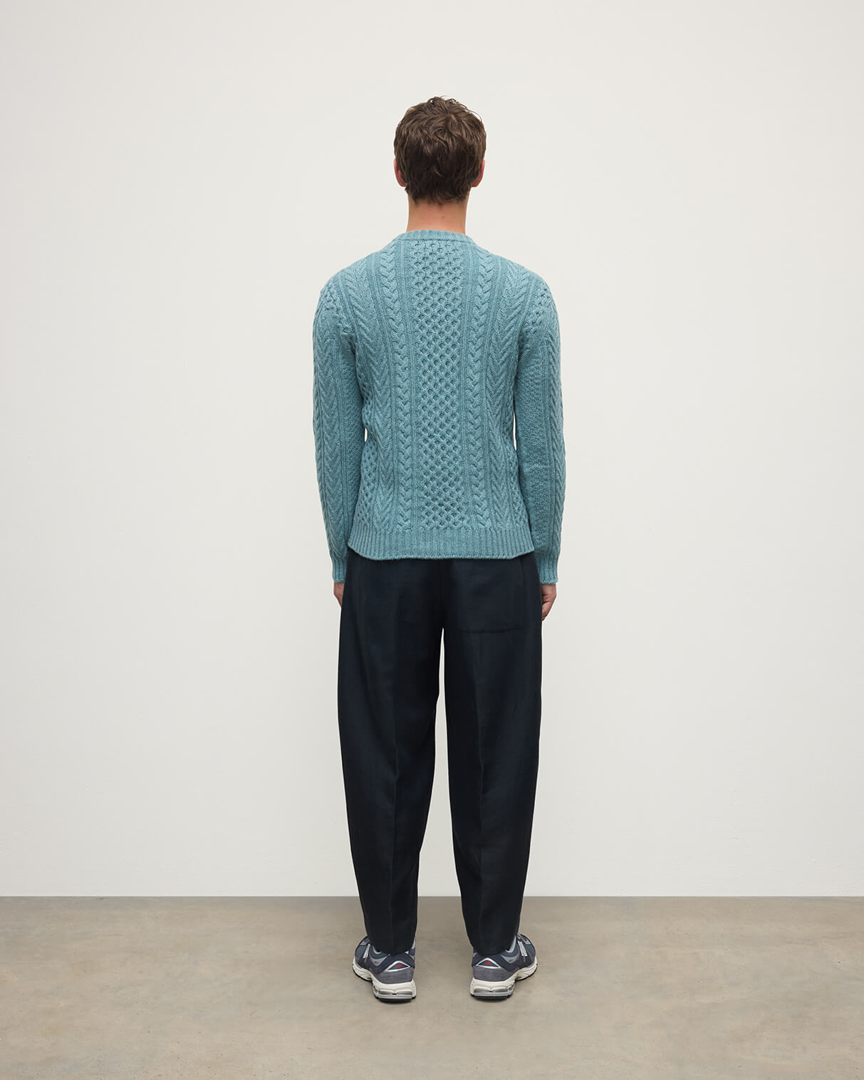 Model wearing Johnstons of Elgin AW25 Men's Knitwear Seascape Aran Cable Green Cashmere Jumper Back KAI05336HC0038