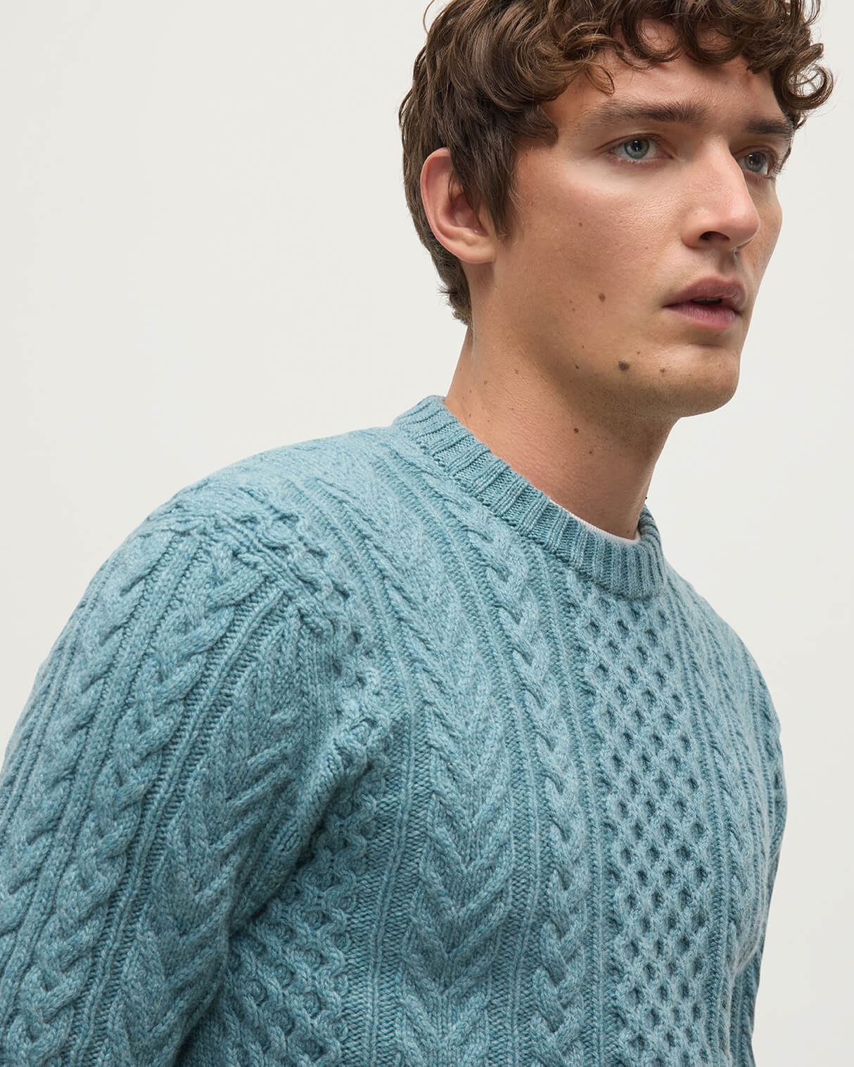 Model wearing Johnstons of Elgin AW25 Men's Knitwear Seascape Aran Cable Green Cashmere Jumper Details KAI05336HC0038