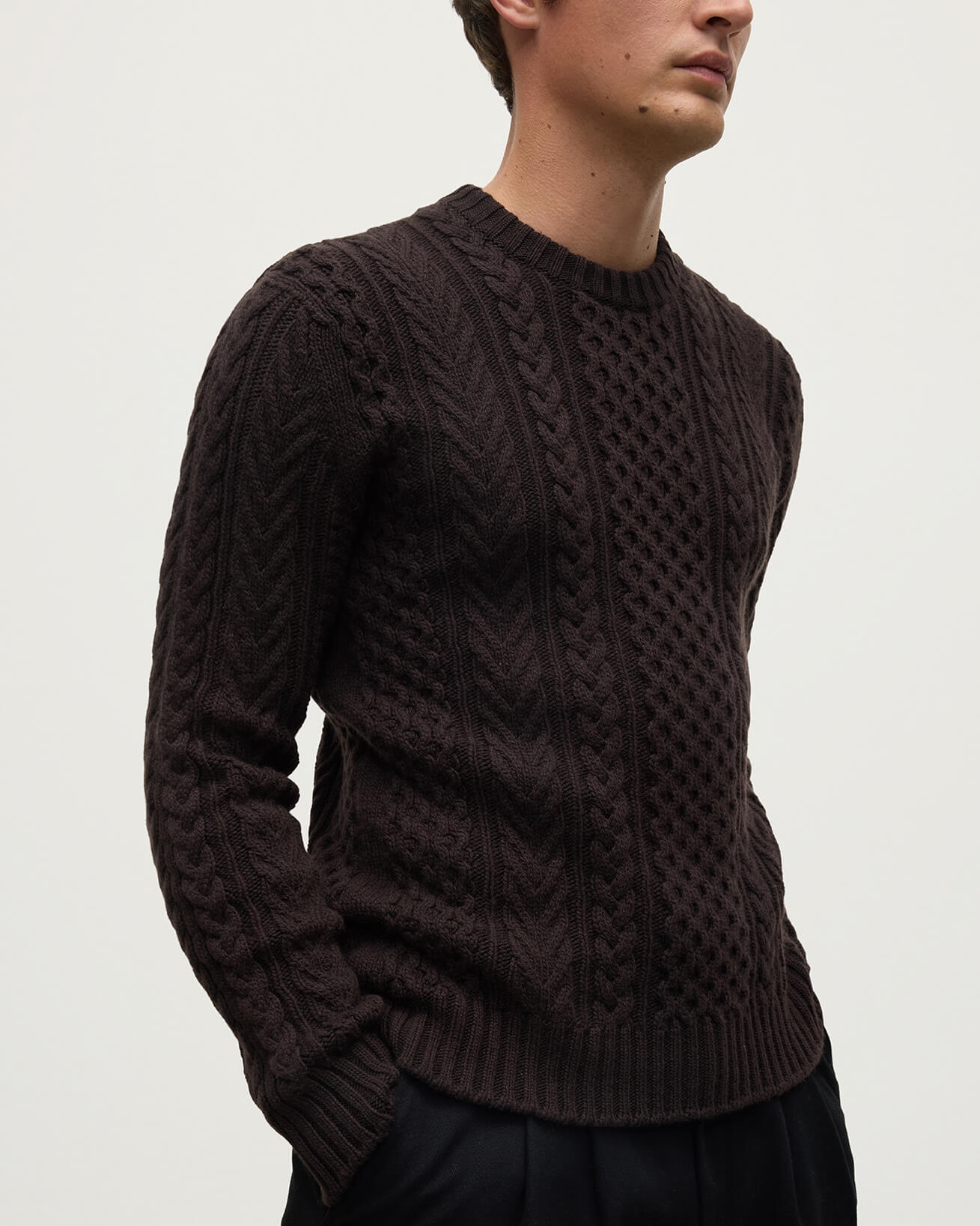 Model wearing Johnstons of Elgin AW25 Men's Knitwear Molasses Aran Cable Brown Cashmere Jumper Details KAI05336SB7290