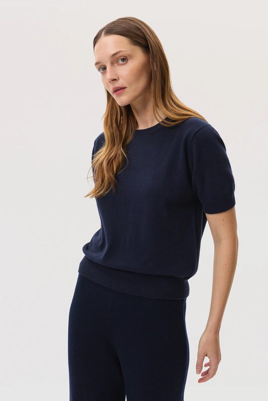 Model wears Johnstons of Elgin SS25 Women's Knitwear Navy Classic Cashmere T-Shirt on a white background KAI05371SD7286