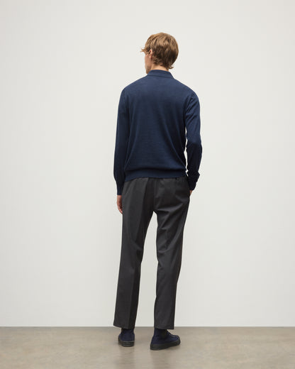 MODEL WEARS JOHNSTONS OF ELGIN MENS FIN SUPERFINE LONG SLEEVE POLOSHIRT NAVY 100% SUPERFINE CASHMERE OVER A WHITE T-SHIRT WITH GREY TROUSERS KAI05481HD7350