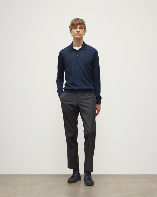 MODEL WEARS JOHNSTONS OF ELGIN MENS FIN SUPERFINE LONG SLEEVE POLOSHIRT NAVY 100% SUPERFINE CASHMERE OVER A WHITE T-SHIRT WITH GREY TROUSERS KAI05481HD7350