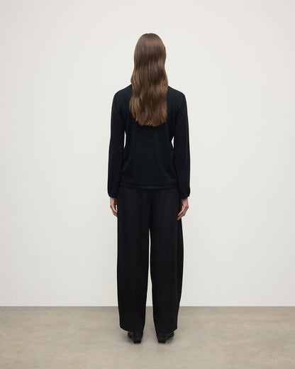 Model wears Johnstons of Elgin AW25 Women's Knitwear Black Superfine Cashmere Black Roll Neck Jumper back  View KAI05607SA7146