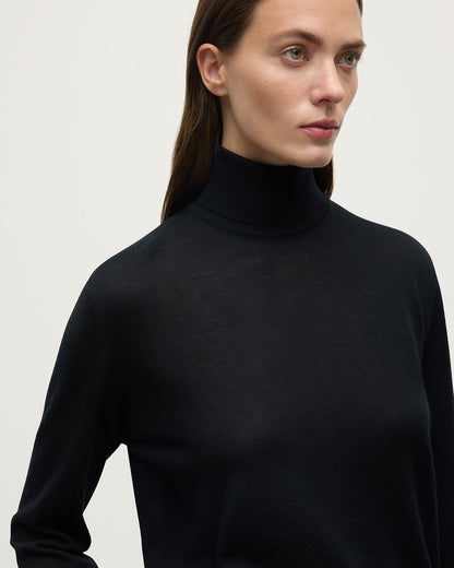 Model wears Johnstons of Elgin AW25 Women's Knitwear Black Superfine Cashmere Black Roll Neck Jumper close up KAI05607SA7146