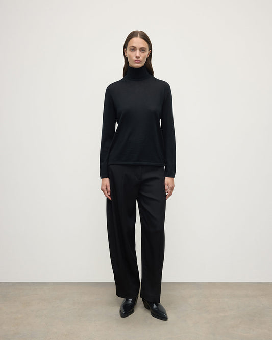 Model wears Johnstons of Elgin AW25 Women's Knitwear Black Superfine Cashmere Black Roll Neck Jumper front View KAI05607SA7146