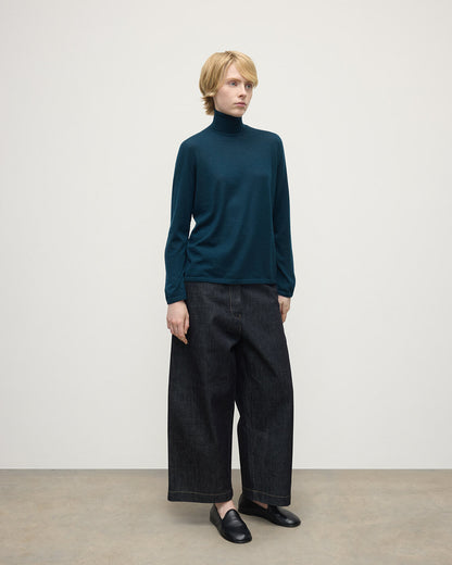 Model wears Johnstons of Elgin AW25 Women's Knitwear Bottle Green Superfine Cashmere Green Roll Neck Jumper Side View  KAI05607SC7344