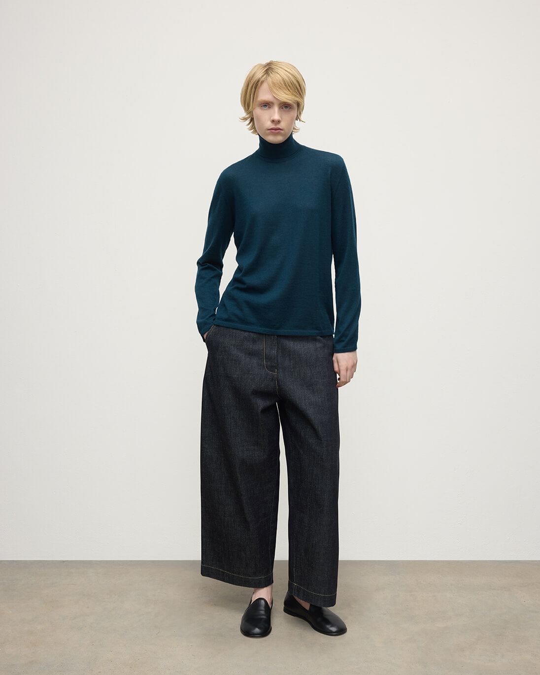 Model wears Johnstons of Elgin AW25 Women's Knitwear Bottle Green Superfine Cashmere Green Roll Neck Jumper Front View  KAI05607SC7344