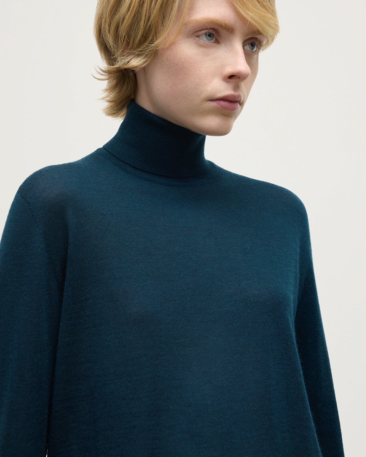 Model wears Johnstons of Elgin AW25 Women's Knitwear Bottle Green Superfine Cashmere Green Roll Neck Jumper Close Up  KAI05607SC7344