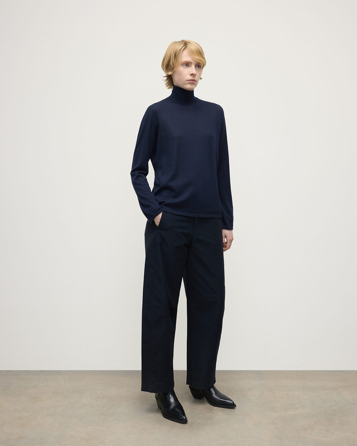 Model wears Johnstons of Elgin AW25 Women's Knitwear Dark Navy Superfine Cashmere Navy Roll Neck Jumper Side View KAI05607SD7600