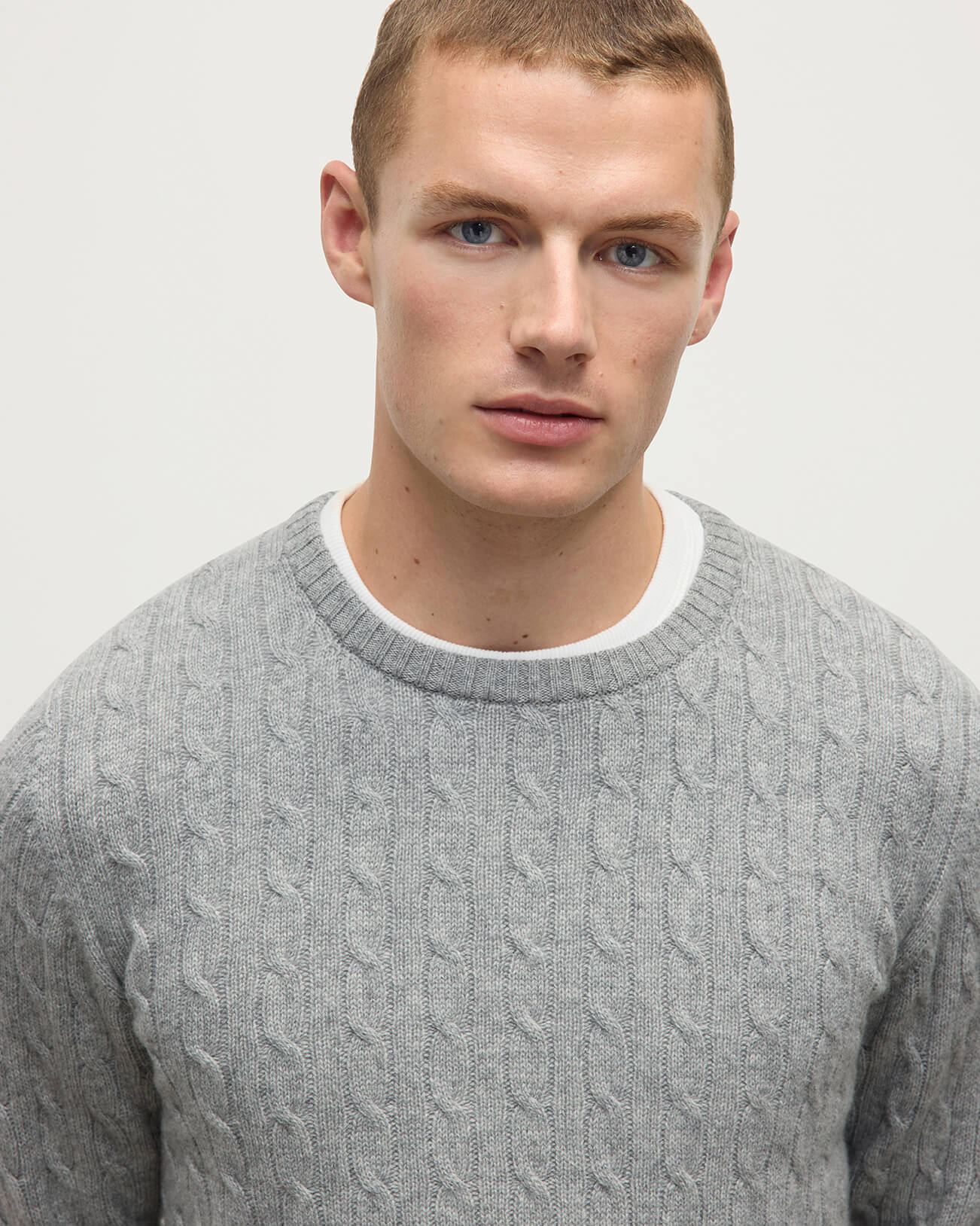 Model wears Johnstons of Elgin AW25 Men's Knitwear Light Grey Cable Knit Grey Cashmere Jumper Details KAI05693HA0308