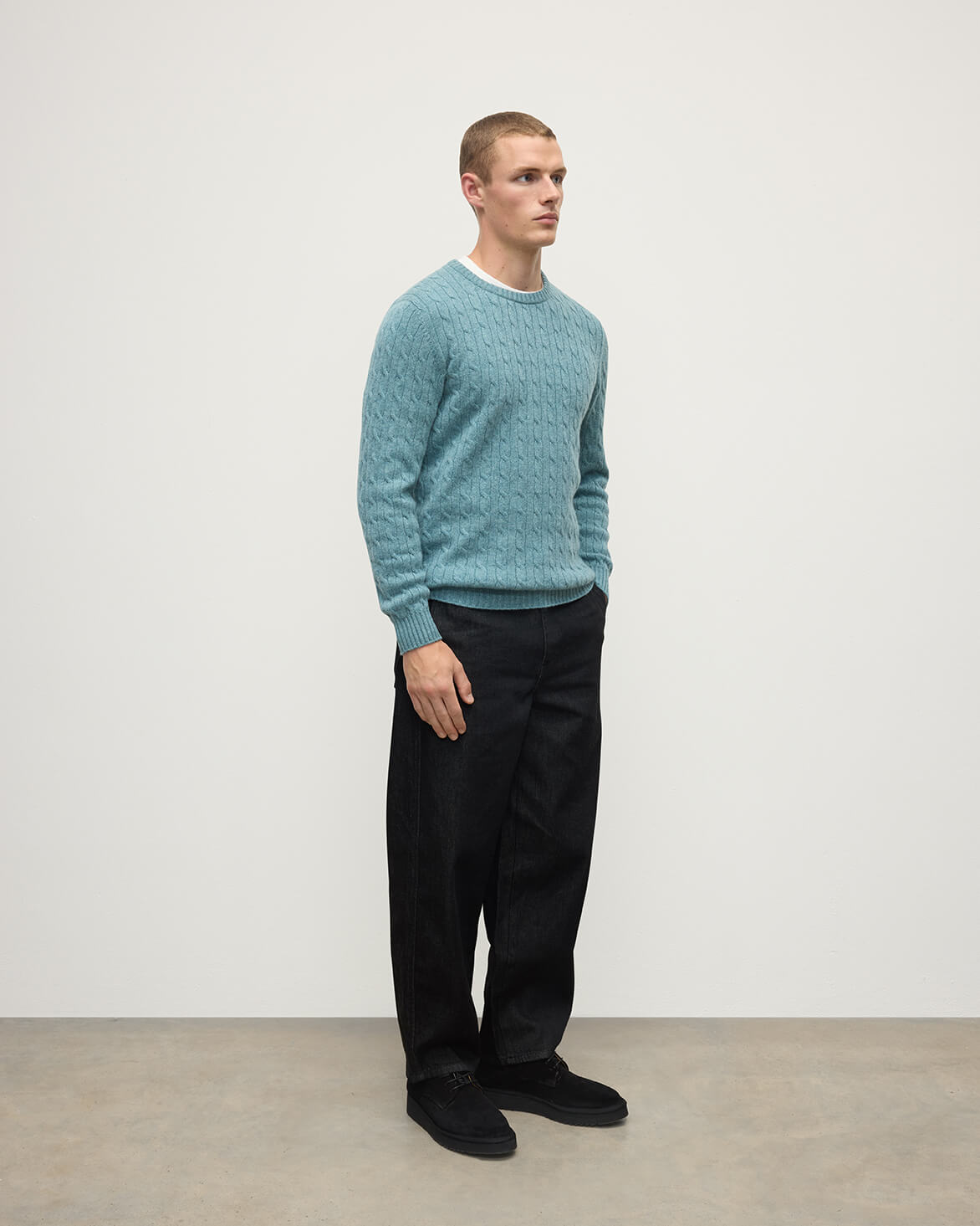 Model wearing Johnstons of Elgin AW25 Men's Knitwear Seascape Cable Knit Green Cashmere Jumper Side KAI05693HC0038