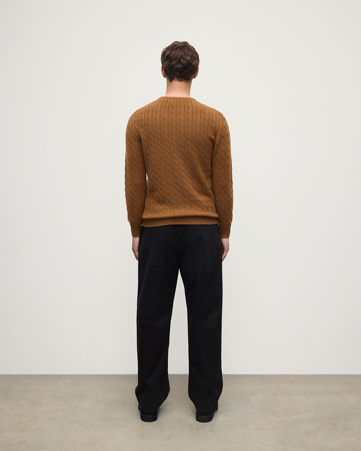 Model wearing Johnstons of Elgin AW25 Men's Knitwear Dark Camel Cable Knit Camel Cashmere Jumper back KAI05693SB4620