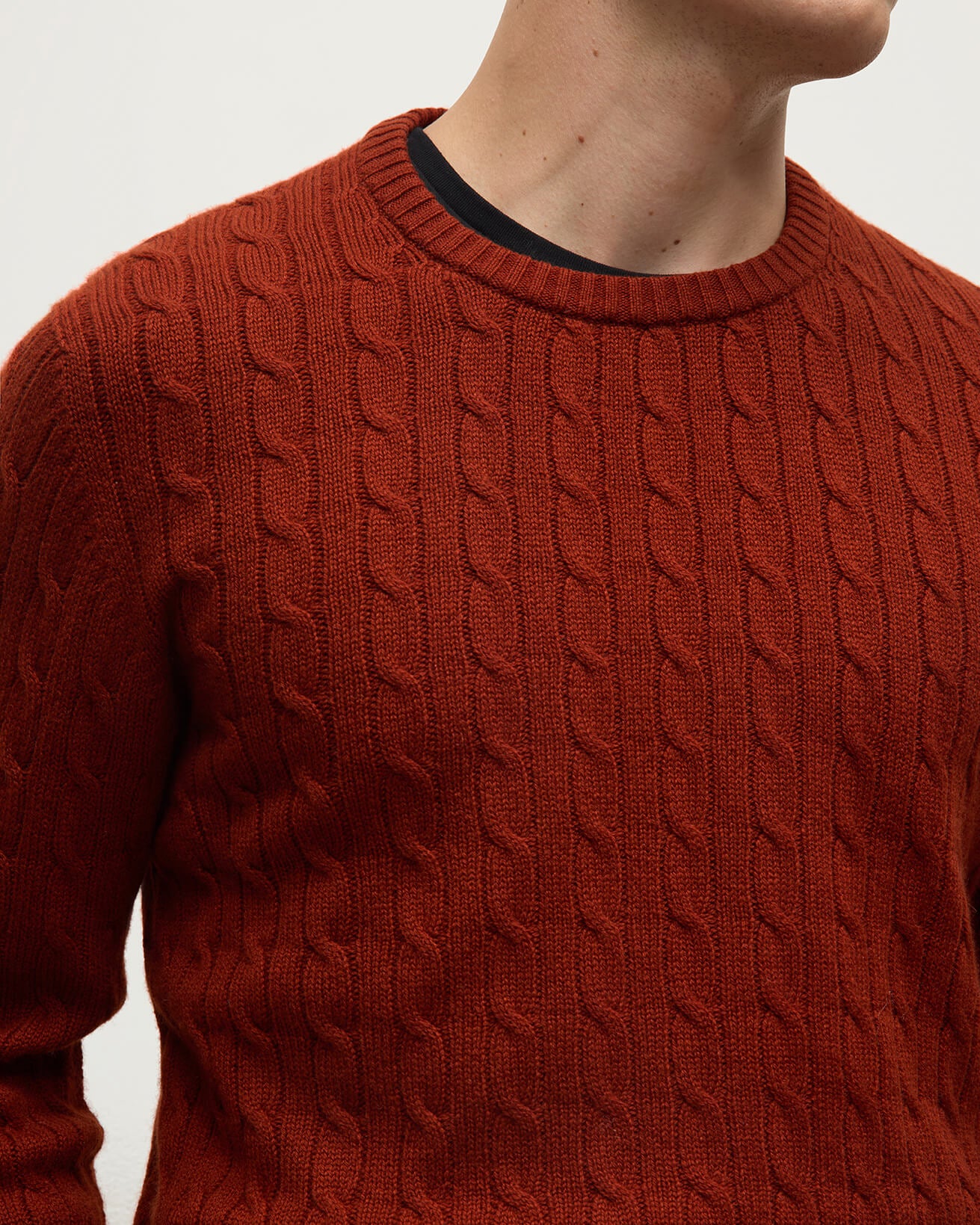 Model wearing Johnstons of Elgin AW25 Men's Knitwear Oxblood Cable Knit Red Cashmere Jumper details KAI05693SG4463